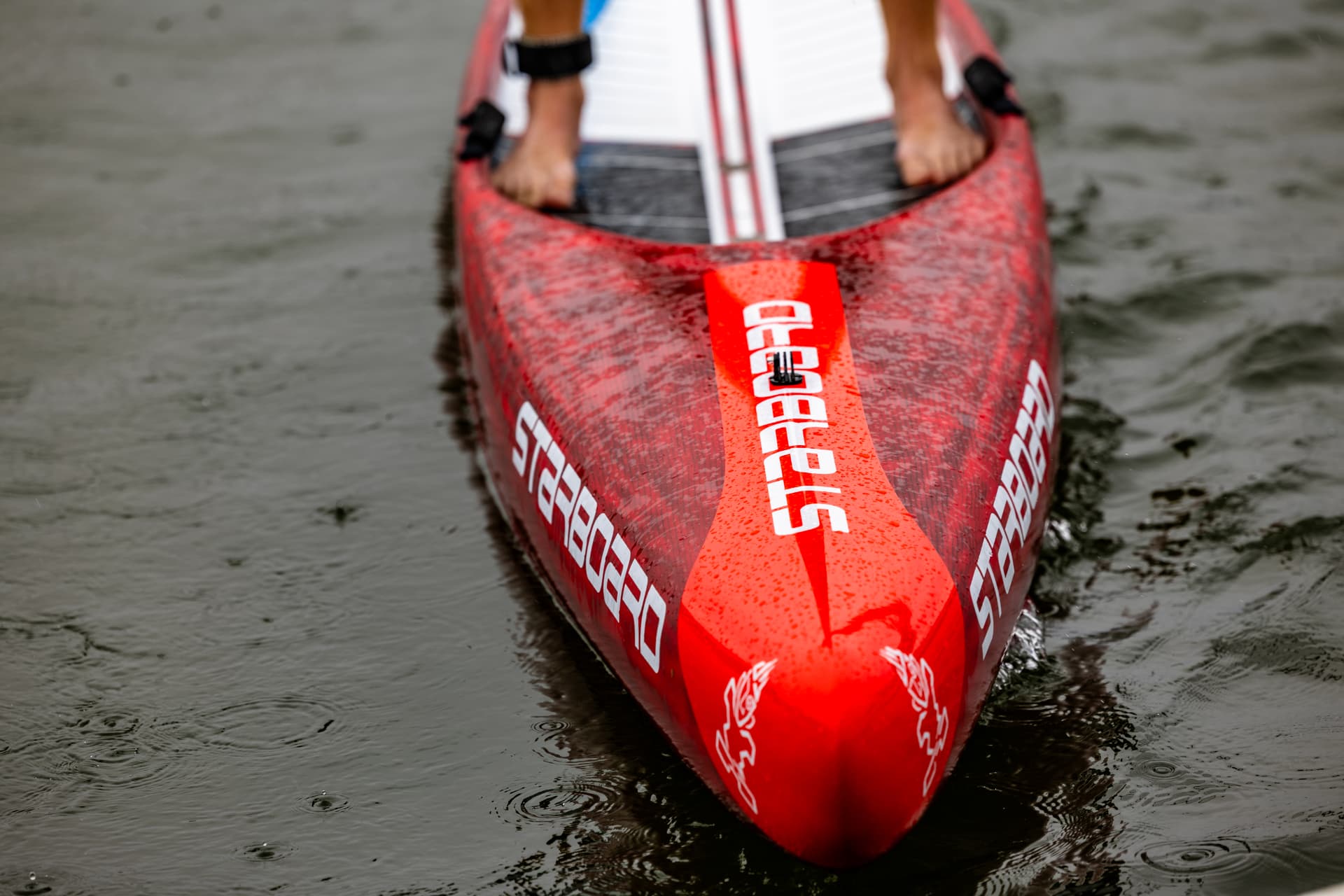 Close-up of a red Starboard race board on the water